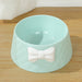 Adorable pet feeding bowl with decorative bow on a wooden floor

