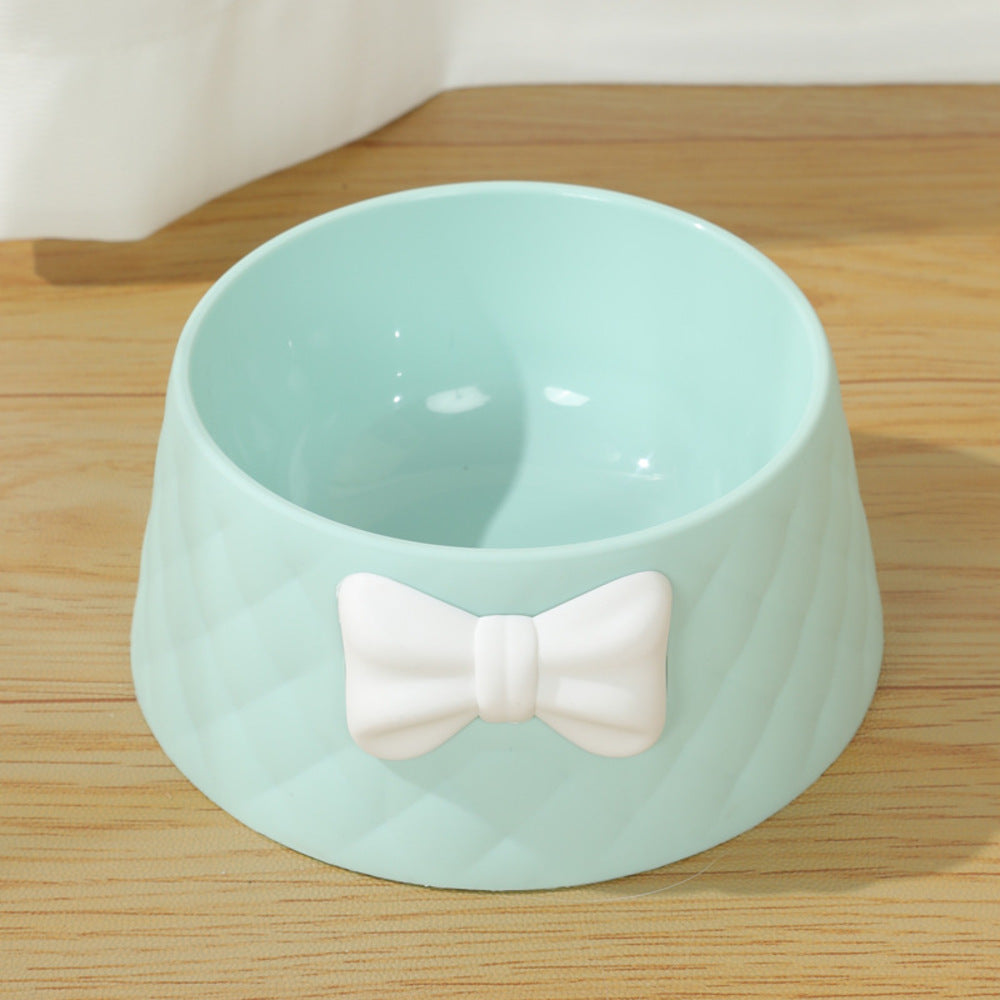 Adorable pet feeding bowl with decorative bow on a wooden floor

